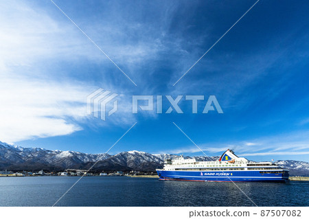 [Niigata Prefecture] Ryotsu Port and Osado Mountains in early spring welcoming passenger ships 87507082
