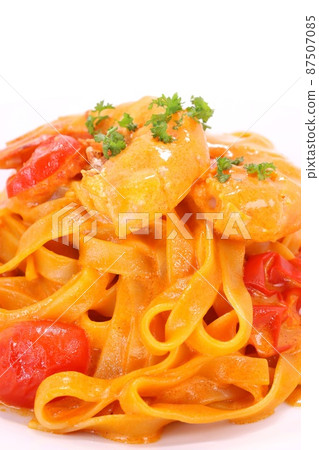 Spaghetti tagliatelle wide pasta with shrimp on a bright background 87507085