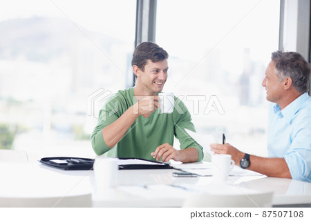 Learning from experience. A young office worker discussing ideas with his boss. Learning from experience. A young office worker discussing ideas with his boss. 87507108