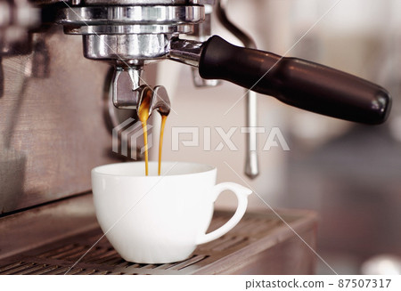 Can you smell the aroma. Shot of freshly brewed coffee dripping into a cup. 87507317