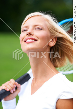 Enjoying the feel of the fresh air in her hair. A young tennis player with the wind in her hair and her racquet on her shoulder. Enjoying the feel of the fresh air in her hair. A young tennis player with the wind in her hair and her racquet on her shoulder. 87507378