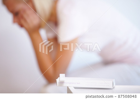 The pregnancy test revealed her worst fear. A young woman waiting anxiously for the results of her pregnancy test. The pregnancy test revealed her worst fear. A young woman waiting anxiously for the results of her pregnancy test. 87508048