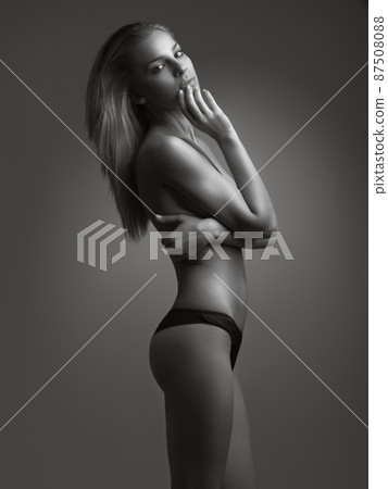 Flawless beauty. Black and white shot of an attractive young woman posing topless in studio. Flawless beauty. Black and white shot of an attractive young woman posing topless in studio. 87508088