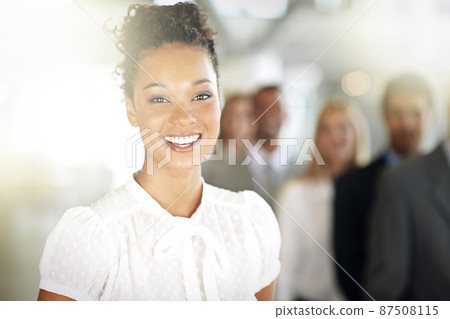 Success always puts a smile on my face. Cropped portrait of a young businesswoman standing in her office with colleagues in the background. Success always puts a smile on my face. Cropped portrait of a young businesswoman standing in her office with colleagues in the background. 87508115