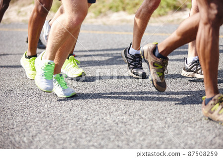 Who will be the winner. Shot of the legs of a group of men running a road race. 87508259