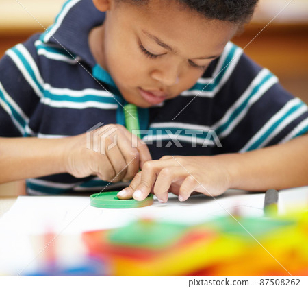 Its creative time. Pre-school african american boy concentrating on his drawings with his crayons and shapes. Its creative time. Pre-school african american boy concentrating on his drawings with his crayons and shapes. 87508262