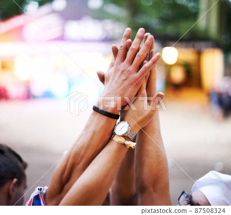 Lets do it. Cropped shot of a group of friends high-fiving at an outdoor festival. Lets do it. Cropped shot of a group of friends high-fiving at an outdoor festival. 87508324