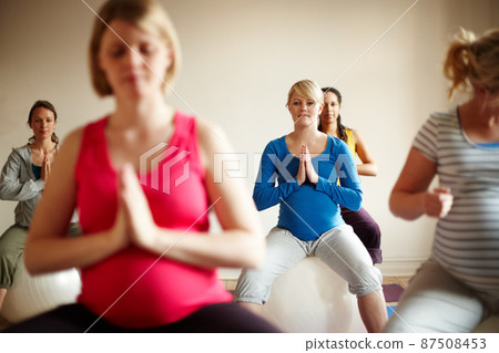 Blissful maternity. A multi-ethnic group of pregnant women meditating on exercise balls in a yoga class. Blissful maternity. A multi-ethnic group of pregnant women meditating on exercise balls in a yoga class. 87508453