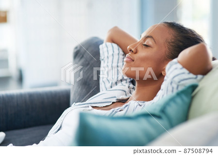 What a quiet and peaceful Sunday afternoon. Shot of a young woman sleeping on the sofa at home. 87508794