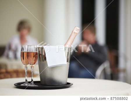 Some bubbly to commemorate the occasion. A champagne bottle and two champagne glasses on a restaurant table. Some bubbly to commemorate the occasion. A champagne bottle and two champagne glasses on a restaurant table. 87508802