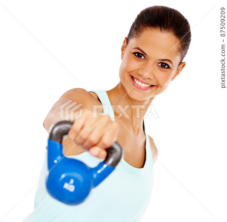 Weight training. Portrait of an attractive young woman exercising with a kettle bell. 87509209