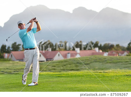 Perfect form and follow through. A male golfer admiring the shot he has just played. Perfect form and follow through. A male golfer admiring the shot he has just played. 87509267