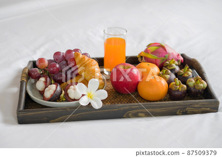 Focus on fruit. In a hotel room with fruit, place a tray on the bed to welcome the arrival of VIP guests Focus on fruit. In a hotel room with fruit, place a tray on the bed to welcome the arrival of VIP guests 87509379