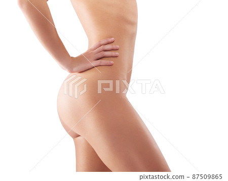 Owning her curves. Studio shot of a beautiful woman posing naked against a white background. 87509865