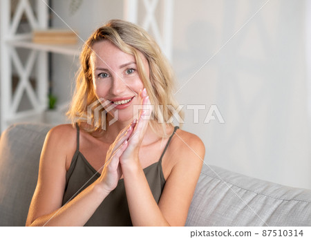 Feminine beauty. Pretty woman. Home relax. Smiling cute lady in stylish look holding hands together sitting sofa in light room interior copy space. Feminine beauty. Pretty woman. Home relax. Smiling cute lady in stylish look holding hands together sitting sofa in light room interior copy space. 87510314