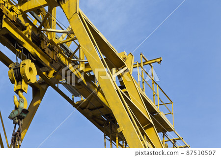 Metal construction of the crane, against the sky, in the warehouse Metal construction of the crane, against the sky, in the warehouse 87510507