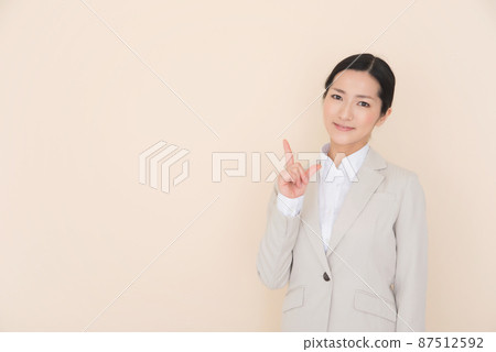 A woman in a suit pointing with her finger 87512592