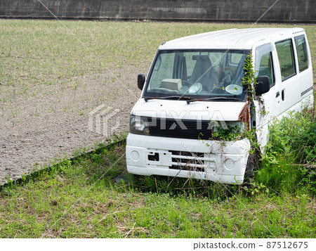 Scrapped car left in the field 87512675