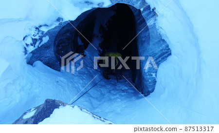 Descent into a deep ice cave. The climber descends Descent into a deep ice cave. The climber descends 87513317