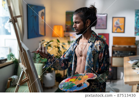 Young contemporary painter with color palette creating new artwork 87513430