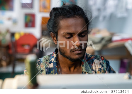 Young contemporary designer of clothes working by sewing machine Young contemporary designer of clothes working by sewing machine 87513434