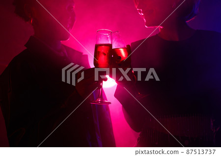 Women Holding Drinks in Neon Light Women Holding Drinks in Neon Light 87513737