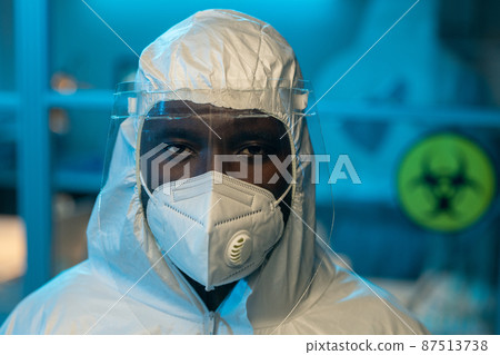 Young contemporary African American scientist in coveralls and respirator Young contemporary African American scientist in coveralls and respirator 87513738