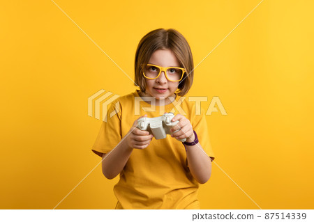 Child with gamepad playing video game 87514339