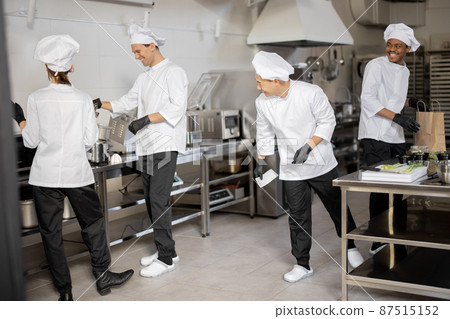 Happy multiracial team of cooks actively work in the kitchen 87515152