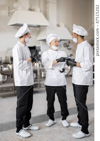 Chefs have some conversation in the professional kitchen at job Chefs have some conversation in the professional kitchen at job 87515202