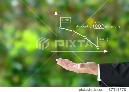 At the hands of a businessman holding a graph of carbon dioxide emissions 87515778