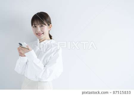 A woman using a mobile phone A woman using a mobile phone 87515833