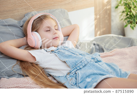 Cute girl listening music in the bedroom Cute girl listening music in the bedroom 87515890