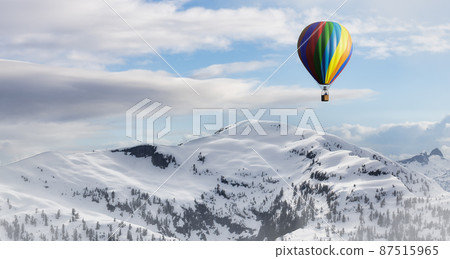 Dramatic Mountain Landscape covered in clouds and Hot Air Balloon Flying Dramatic Mountain Landscape covered in clouds and Hot Air Balloon Flying 87515965