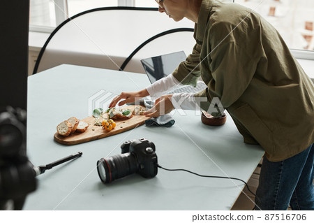 Food Photographer Arranging Scene 87516706