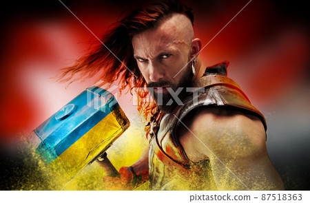 Portrait of brave, courage man, warrior with huge hammer painted in blue-yellow colors of Ukrainian flag. Conceptual collage Portrait of brave, courage man, warrior with huge hammer painted in blue-yellow colors of Ukrainian flag. Conceptual collage 87518363