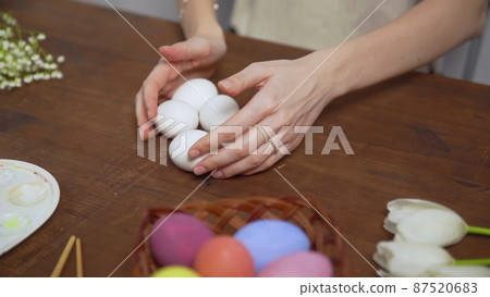 Close-up on a table with items to create a composition for Easter. Women's hands arrange objects on the table. Church holiday-Easter Close-up on a table with items to create a composition for Easter. Women's hands arrange objects on the table. Church holiday-Easter 87520683