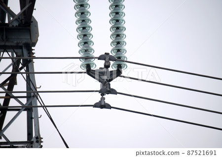 High voltage tower with electric power lines divided by safe guard bushing transfening safely electrical energy through cable wires. Electricity transmission on long distance concept 87521691