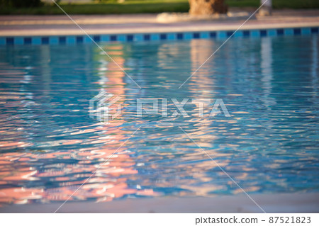 Closeup surface of blue clear water with small ripple waves in swimming pool. Closeup surface of blue clear water with small ripple waves in swimming pool. 87521823
