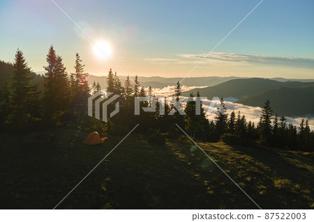 Aerial view of tourist camping tent on mountain campsite at bright sunny evening. Active tourism and hiking concept Aerial view of tourist camping tent on mountain campsite at bright sunny evening. Active tourism and hiking concept 87522003