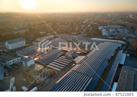 Aerial view of solar power plant with blue photovoltaic panels mounted on industrial building roof for producing green ecological electricity. Production of sustainable energy concept 87522005