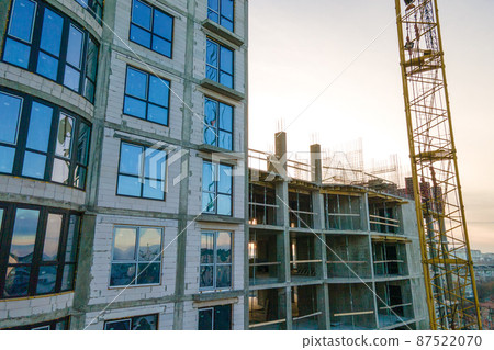 Aerial view of high tower crane and residential apartment buildings under construction. Real estate development. 87522070