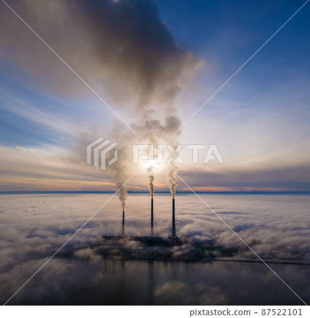 Aerial view of coal power plant high pipes with black smoke moving up polluting atmosphere at sunset Aerial view of coal power plant high pipes with black smoke moving up polluting atmosphere at sunset 87522101