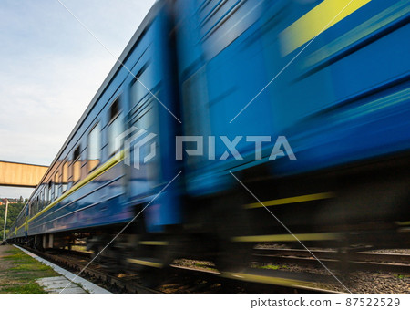 a blue passenger train travels along the track a blue passenger train travels along the track 87522529