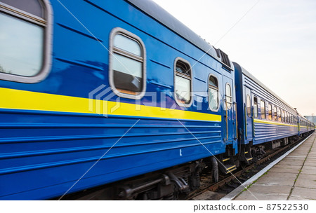 a blue passenger train travels along the track a blue passenger train travels along the track 87522530