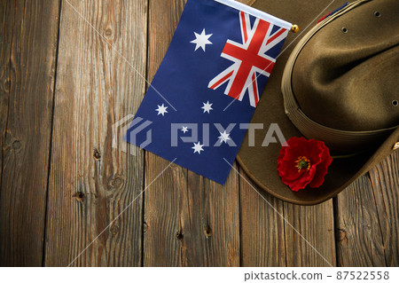 Anzac army slouch hat with Australian Flag and Poppy on wooden background 87522558