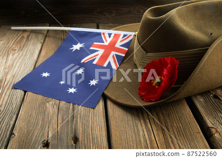 Anzac army slouch hat with Australian Flag and Poppy on wooden background 87522560