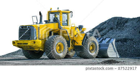 Yellow wheeled loader on front of pile of gravel isolated on white background 87522917