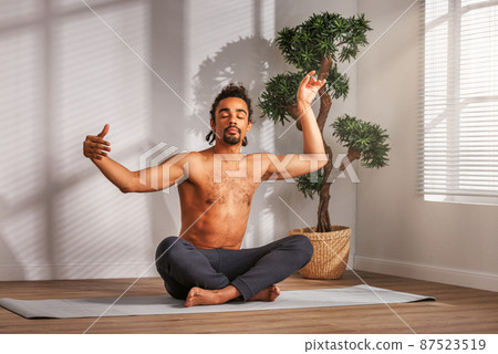 Calm African American man meditating in morning Calm African American man meditating in morning 87523519