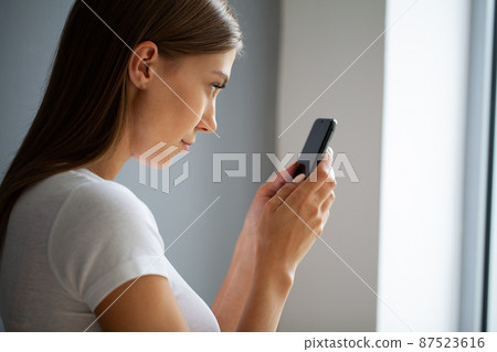 The young woman does not look away from the phone 87523616